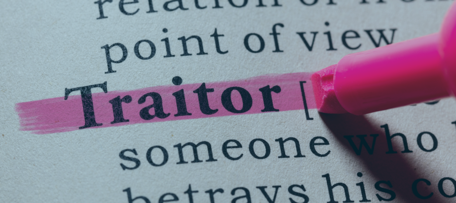 dicationary page with the word traitor highlighted in pink