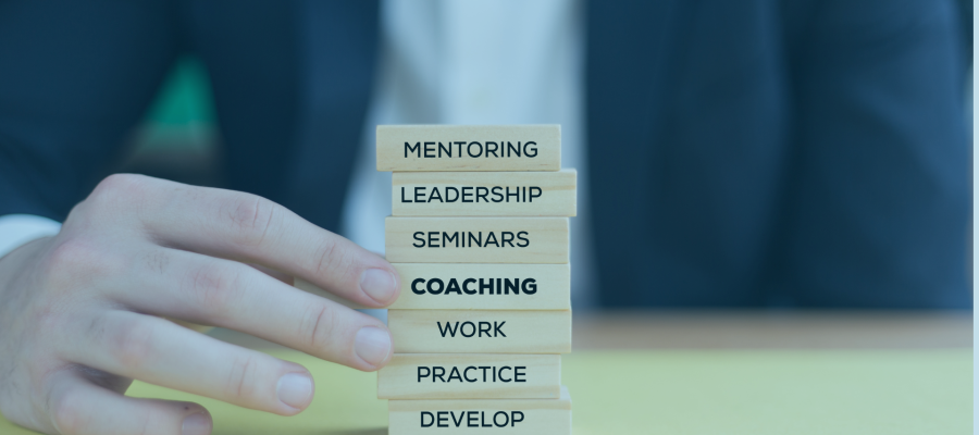 male hand holding bricks saying mentoring coaching